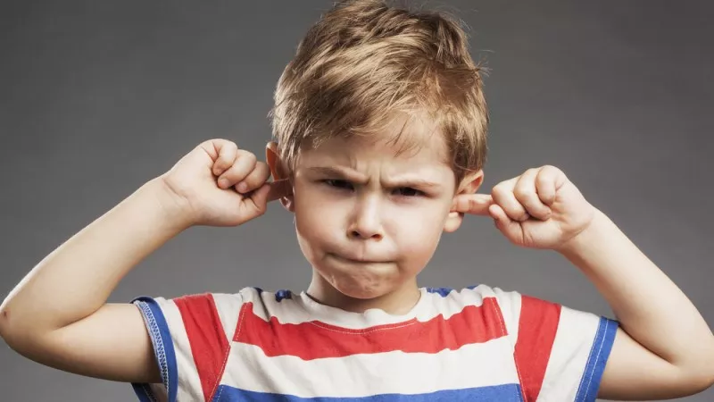 Garcon qui se bouche les oreilles